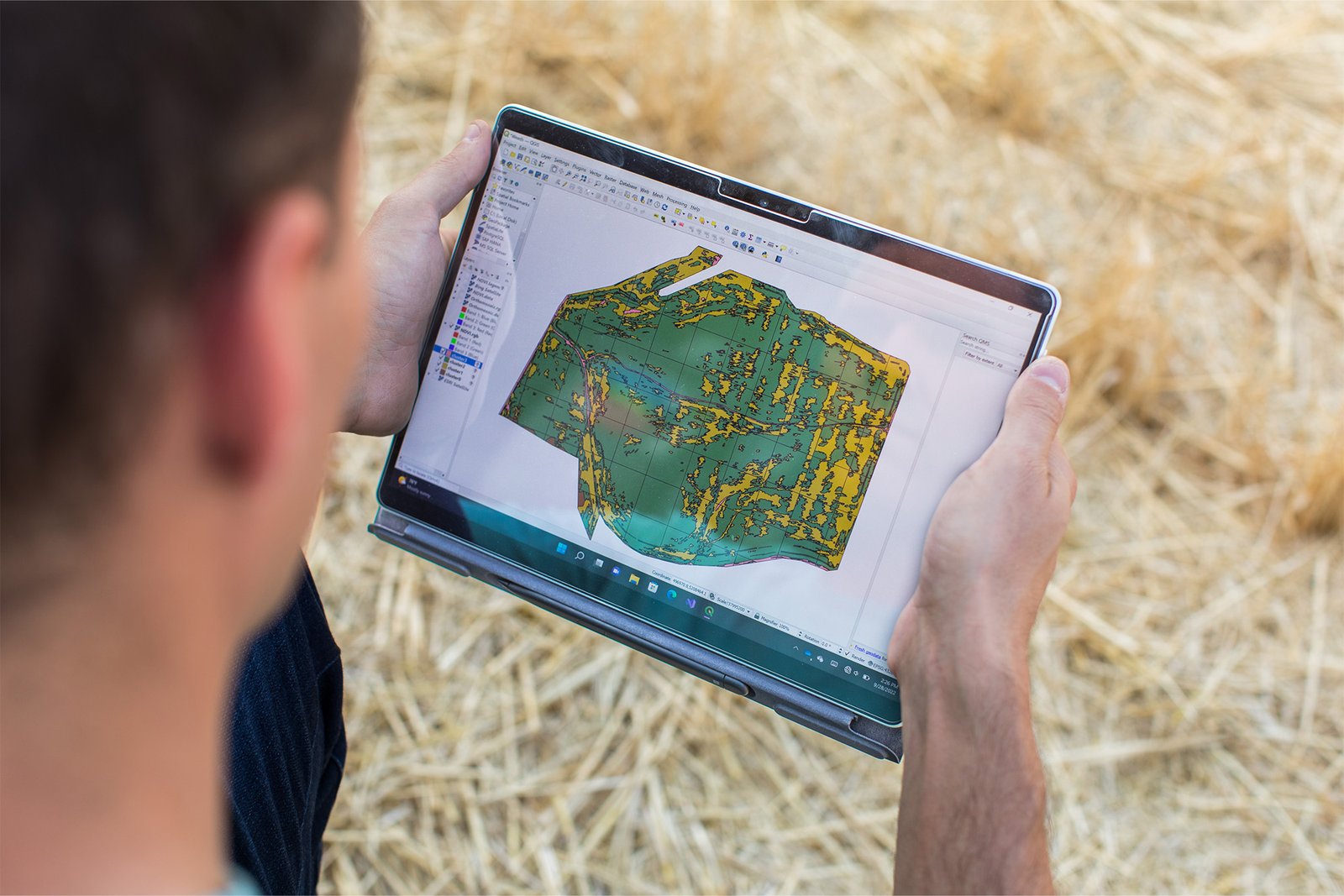 Un homme contient une tablette montrant un igège multispectral d'un champ.