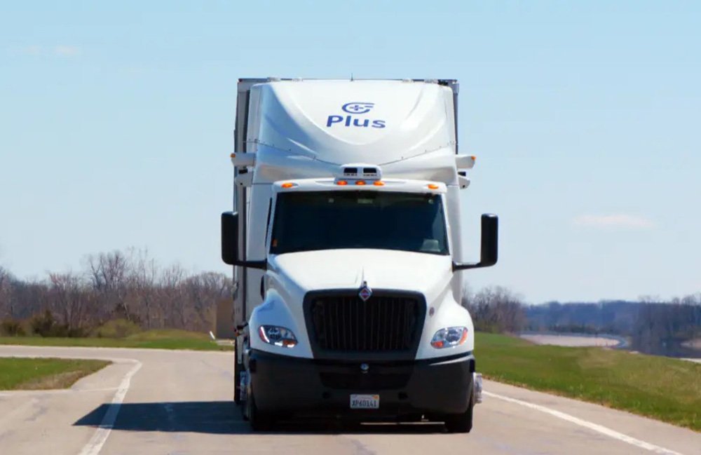 Un camion plus conduisant sur une route.