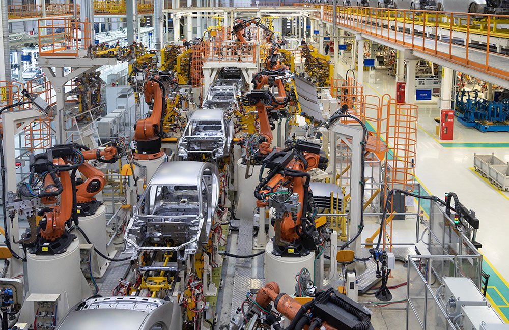 Une chaîne de montage automobile avec plusieurs voitures de construction de robots industriels orange.