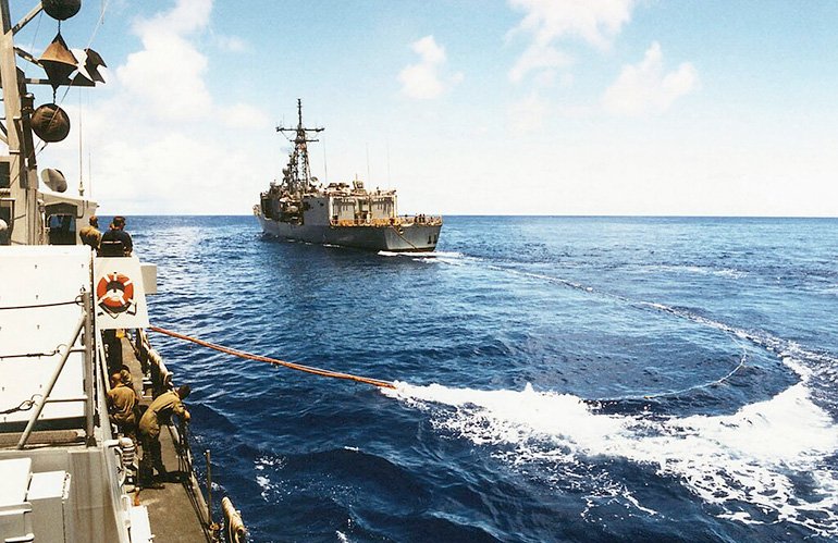 A view taken from onboard the US Navy (USN) Cyclone Class Coastal Defense Ship, USS HURRICANE (PC 3), showing as a trailing refueling line being extended from the USN Oliver Hazard Perry Class: Guided Missile Frigate, USS JOHN H. SIDES (FFG 14), as the two ships conduct Replenishment At Sea (RAS) operations while underway in the Pacific Ocean participating in a Coordination Afloat Readiness and Training (Carat) Exercice, lors de l'exécution de la première croisière trans-pacifique d'un bateau des forces de patrouille.