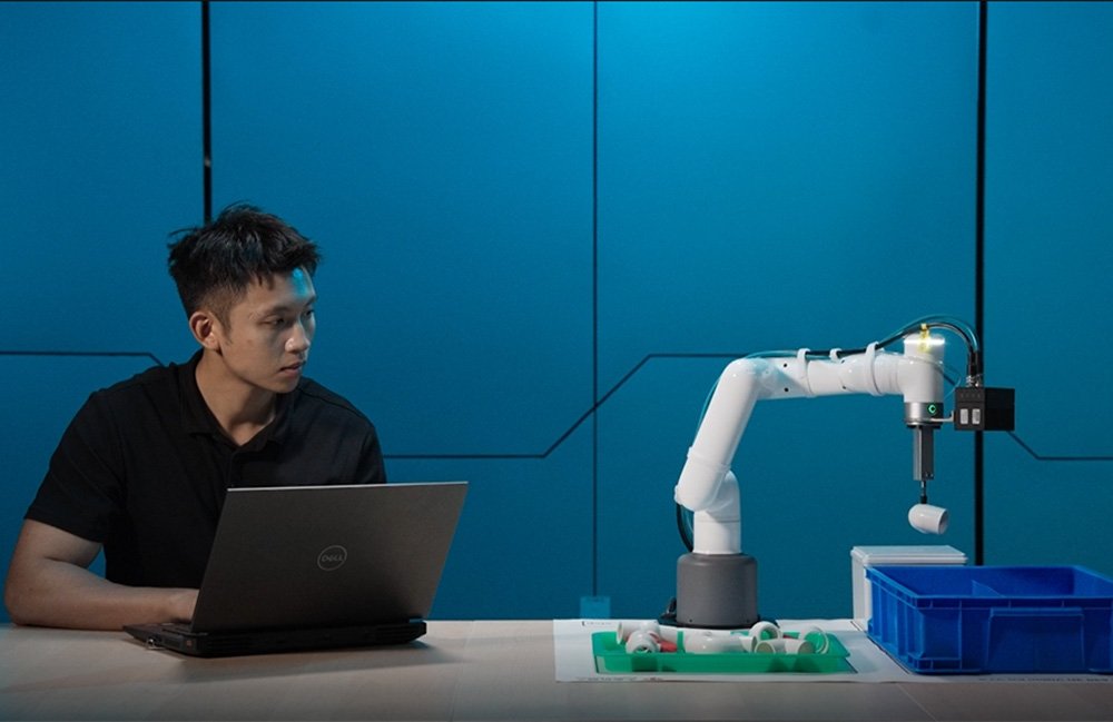 Une personne contrôlant le Mycobot Pro 450 avec un ordinateur portable.